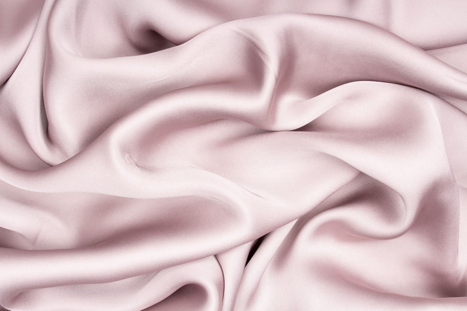 Folds of pale pink silk in soft light